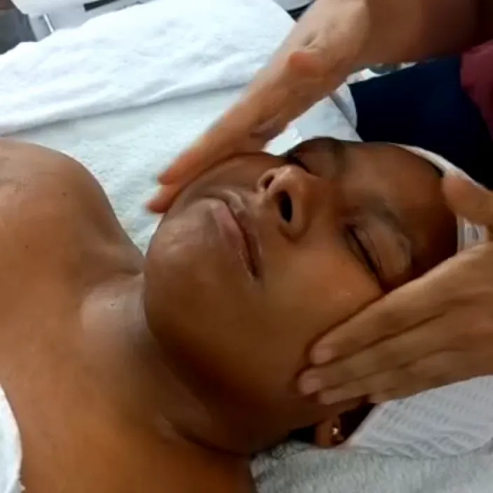 Masaje facial en cabina durante una práctica de cosmetología